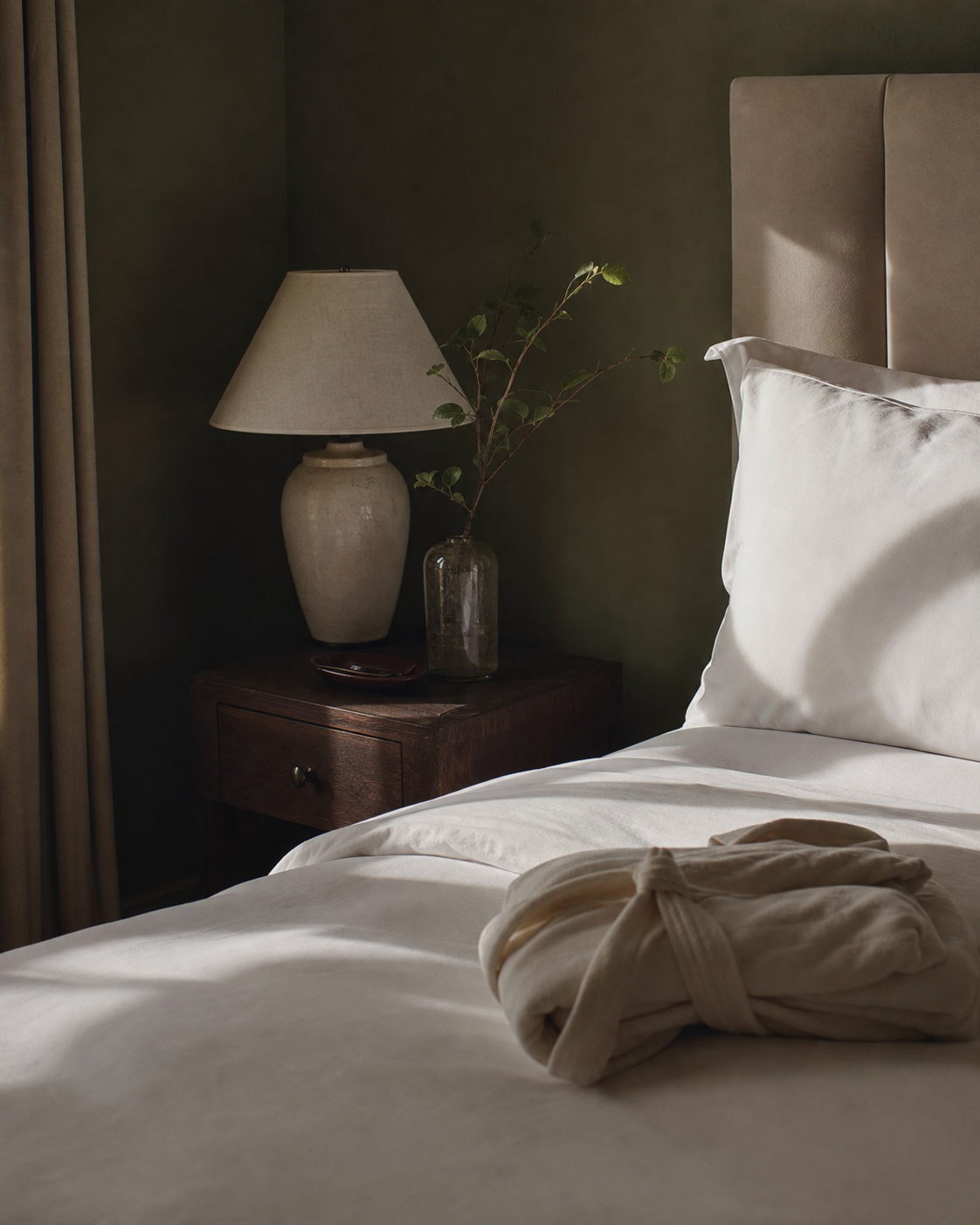 A carefully prepared bedroom with soft linen and warm morning light